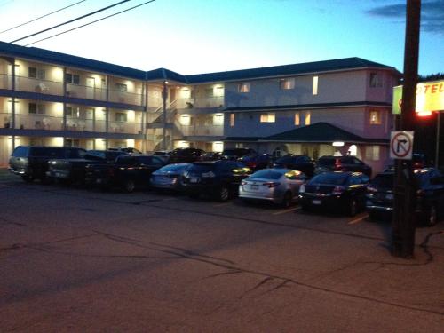 a parking lot with cars parked in front of a building at Motel 99 in Grand Forks