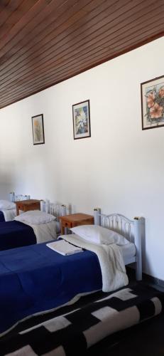 Un dormitorio con dos camas con sábanas azules y blancas. en Pousada Pedacinho do Céu -Chalé Familia, en Cunha