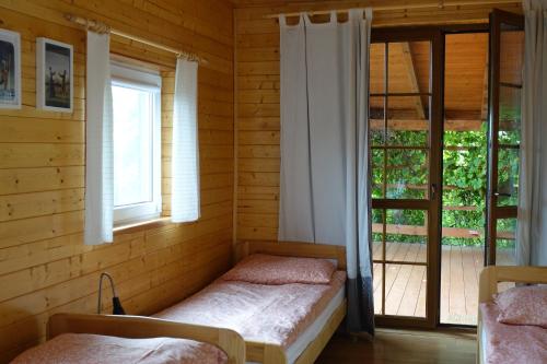a room with two beds in a room with a window at Agroturystyka Bogdanki in Stary Targ