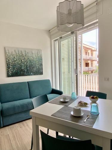 a living room with a table and a blue couch at Aura Marina Casa Vacanze in Polignano a Mare
