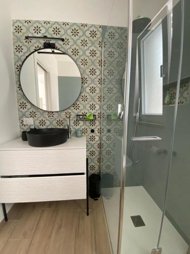 a bathroom with a mirror and a sink and a shower at Aura Marina Casa Vacanze in Polignano a Mare