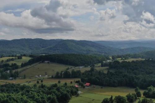 an aerial view of a field with trees and mountains at Fox Trot Cabin in Meadows of Dan