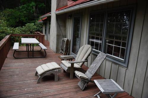 a wooden deck with chairs and a table and a table at Fox Trot Cabin in Meadows of Dan