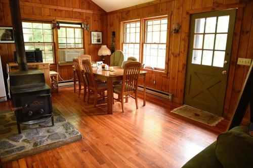 a dining room with a table and a stove at Fox Trot Cabin in Meadows of Dan