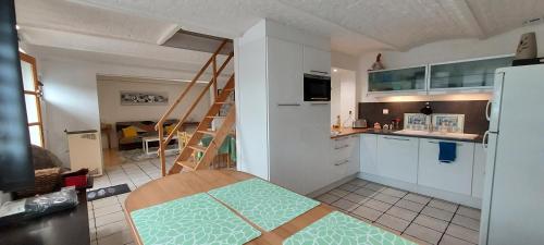 une cuisine avec un escalier au milieu d'une pièce dans l'établissement Gite La Maisonnette Beuvrygeoise, à Beuvry