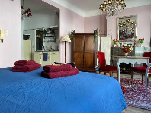 a bedroom with two red pillows on a blue bed at The Pink Studio - Exceptional location IN city center - Unique & Elegant in Namur