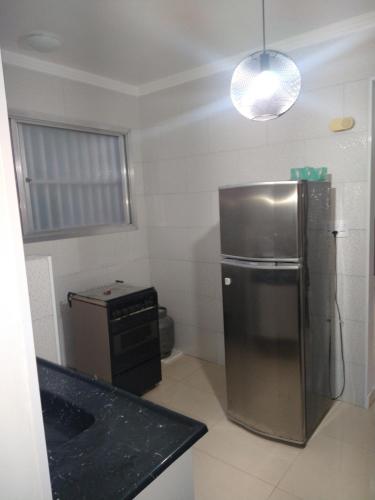 a kitchen with a stainless steel refrigerator and a sink at Apartamento Boqueirao in Praia Grande