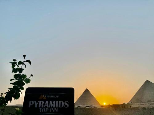 a sign in front of the pyramids at sunset at Pyramids Top Inn in Cairo