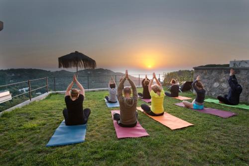 a group of people doing yoga on the grass at San Montano Resort & Spa in Ischia