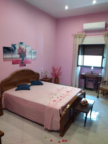 una camera da letto con un grande letto e pareti rosa di Nonno Ciccio Apartment a Lizzano