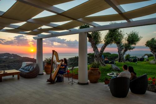 a patio area with chairs, tables and umbrellas at San Montano Resort & Spa in Ischia
