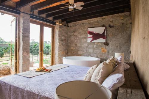 - une chambre avec un lit et une baignoire dans l'établissement Hotel de Tierra Viñedo y Spa - Aeropuerto Querétaro, à San Vicente