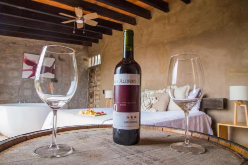 - une bouteille de vin et 2 verres à vin sur une table dans l'établissement Hotel de Tierra Viñedo y Spa - Aeropuerto Querétaro, à San Vicente