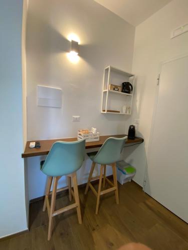 een kleine keuken met 2 stoelen en een bureau bij B&B Alis Home in Brindisi