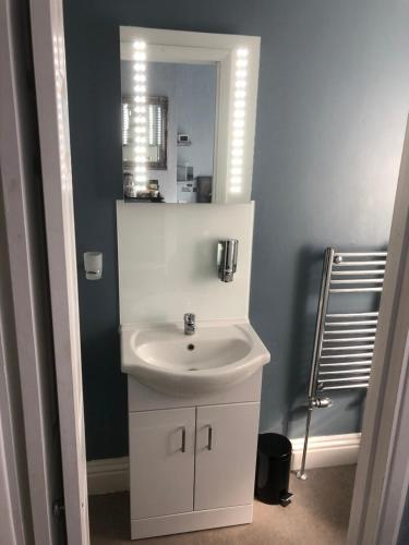 a bathroom with a white sink and a mirror at Swanage Haven Boutique Guest House in Swanage