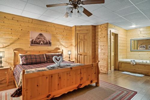 a bedroom with a bed and a ceiling fan at Cozy log cabin!! In heart of PF & close to the Smokies in Pigeon Forge