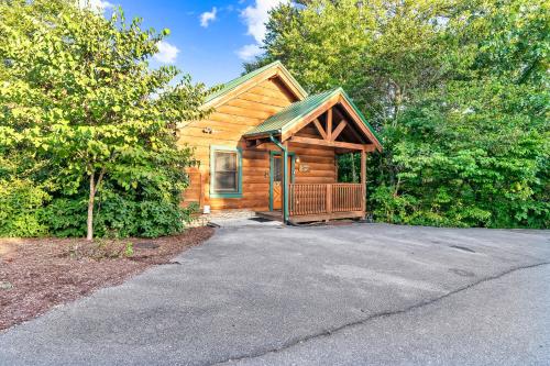 a log cabin with a porch and a driveway at Cozy log cabin!! In heart of PF & close to the Smokies in Pigeon Forge
