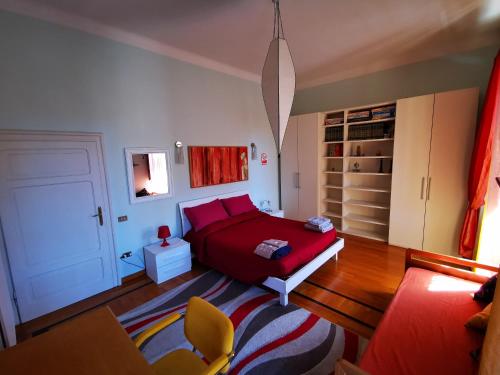 ein Schlafzimmer mit einem roten Bett und einem Sofa in der Unterkunft Liberty House in Foligno