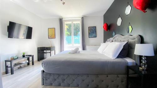 1 dormitorio con 1 cama grande y TV en Joli studio avec jardin - Gare RER C -proche PARIS en Brétigny-sur-Orge