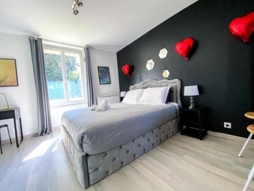 a bedroom with a bed with red hearts on the wall at Joli studio avec jardin - Gare RER C -proche PARIS in Brétigny-sur-Orge