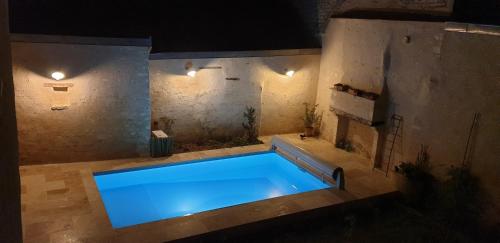 a swimming pool with blue water in a room at La Croix au Maitre in Coulanges-la-Vineuse