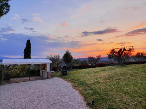 a path in a field with a sunset in the background at Antico Casale Tiravento in Passignano sul Trasimeno
