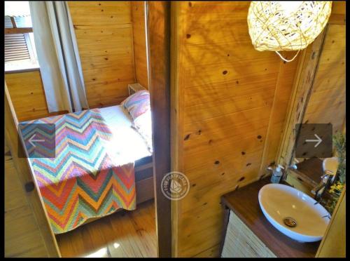 a small room with a bed and a sink at Fama in Punta Del Diablo