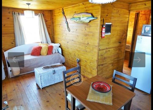 um quarto com uma cama e uma mesa num quarto em Fama em Punta Del Diablo