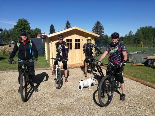 a group of people riding bikes in front of a cabin at Apartmány HABR in Nové Město pod Smrkem