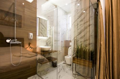 y baño con lavabo, aseo y ducha. en East & West Apartments, en Belgrado