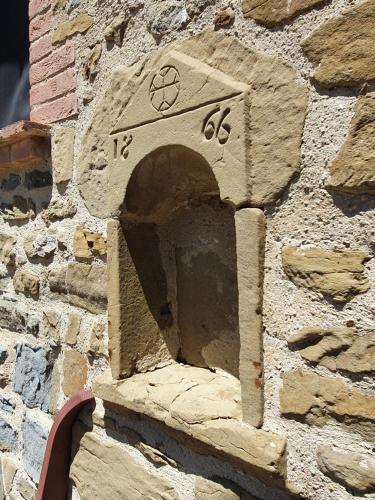 a stone clock on the side of a stone wall at Antico Casale Tiravento in Passignano sul Trasimeno