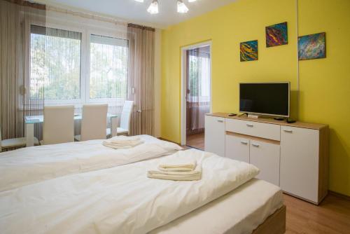 um quarto com uma cama grande e uma televisão. em Otthon-Laksz apartman em Nyíregyháza