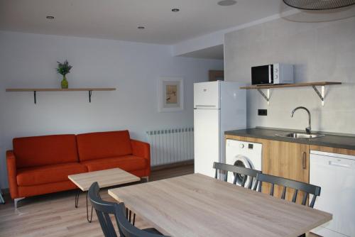 a kitchen and living room with a table and a couch at Apt Nuevos con caballos Fio de Neu Laspaules in Laspaúles