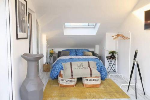 une chambre avec un lit avec des oreillers bleus dessus dans l'établissement Reims Centre : appartement lumineux et atypique 46, Place d'Erlon, à Reims