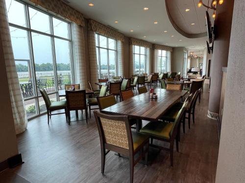 a dining room with tables and chairs and windows at Holiday Inn Owensboro Riverfront by IHG in Owensboro