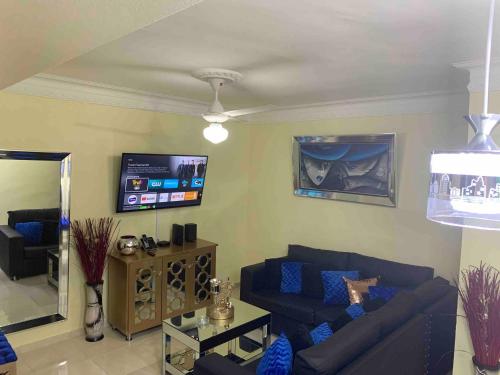 a living room with a couch and a tv at Entire Apartment Tu Nido De Amor netflix Wifi in Santo Domingo