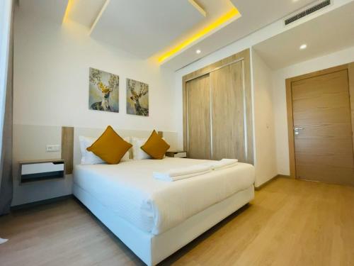 - une chambre avec un grand lit blanc et des oreillers jaunes dans l'établissement Zen Apartment in the center of Tangier, à Tanger