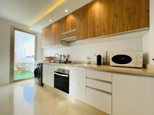 y cocina con microondas y fogones. en Zen Apartment in the center of Tangier, en Tánger