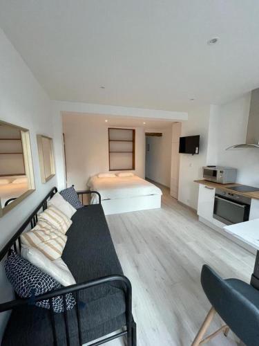 sala de estar con sofá y cama en Le cottages des remparts - le lodge en Boulogne-sur-Mer