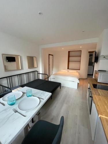 um quarto com duas camas e uma mesa e uma cozinha em Le cottages des remparts - le lodge em Boulogne-sur-Mer