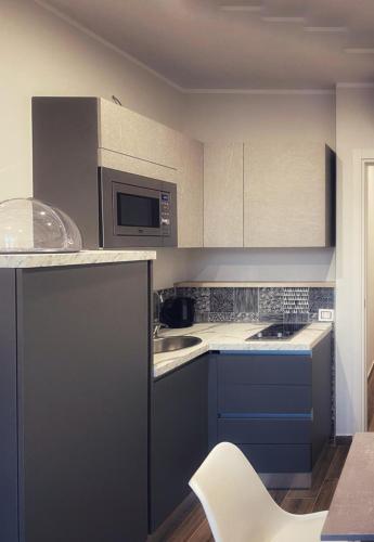 a kitchen with blue cabinets and a white chair at Lumarooms B&B in Reggio Calabria