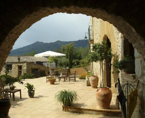 an archway with potted plants on a patio at Can Vila in Sant Julià del Llor