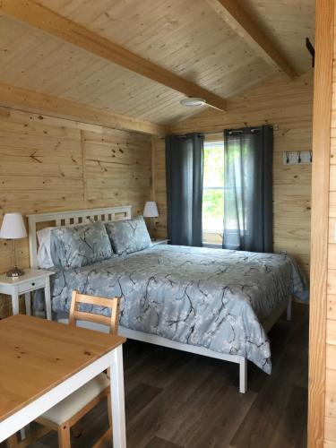 a bedroom with a bed in a wooden cabin at Les chalets de la colline inc in Baie-Sainte-Catherine