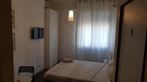 a small room with a bed and a television at B&B Diana in Bologna
