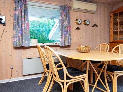 een eetkamer met een houten tafel en stoelen bij 6 person holiday home in Oksb l in Oksbøl