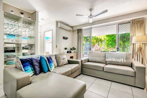 a living room with two couches and a window at Ramada Encore by Wyndham Whale Cove in Hervey Bay