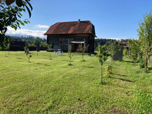an old barn in a field with trees at Wooden Barn in Zăbala