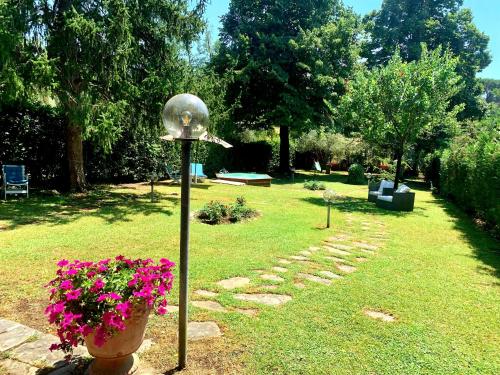 a garden with a birdbath and flowers in a yard at Villa Lia - Apartment in Villa with private garden and Pool in Florence