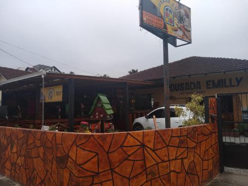a restaurant with a sign in front of a building at Pousada Emilly in Joinville