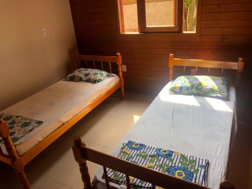 a bedroom with two beds in a cabin at Casa em Ibiraquera próxima a praia do Rosa in Imbituba